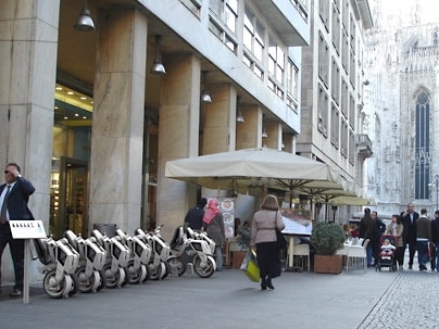 The low cost and foldable design of these electric scooters, as shown in this rendering outside the Duomo in Milan, could provide a convenient and efficient mode of transportation in urban environments.