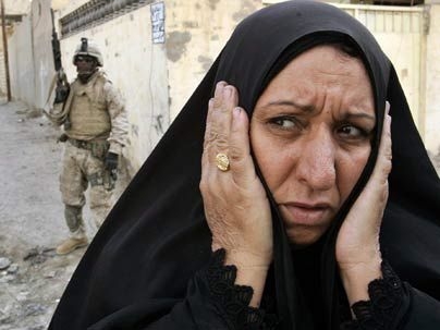 An Iraqi woman tries to flee fighting in the center of Fallujah in November 2004.