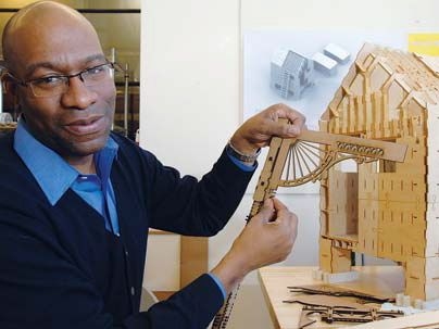 Larry Sass, assistant professor of architecture, is making a digitally fabricated replica of a 'shotgun' house typical of New Orleans. Here he works with laser-cut ornaments to go on the faÃ§ade of the building.