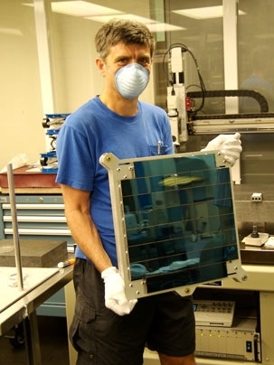 John Tonry of the Institute for Astronomy holds an entire array of 60 chips; an array of 60 OTAs will be installed in the focal plane of each of the four cameras in the Pan-STARRS facility.