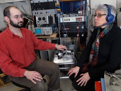 Here Senior Research Scientist Charlotte Reed speaks while the device she helped develop converts the sounds into vibrations. Graduate research assistant Theodore Moallem uses the device to read her lips and feel the sounds.