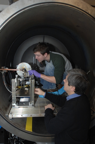Department of Aeronautics and Astronautics graduate student Taylor Matlock, left,  and principal research scientist Oleg V. Batishchev work on adjusting a prototype of a new plasma rocket.