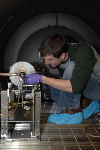 Department of Aeronautics and Astronautics graduate student Taylor Matlock works on adjusting a prototype of a new plasma rocket.