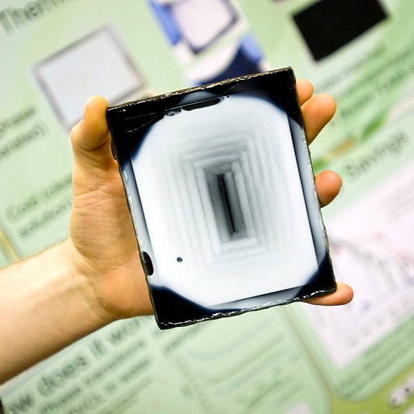 A blast from a heat gun has turned most of the black tile in this image white. The prototype tile, developed by recent MIT graduates, is designed to turn dark in cold weather and white in warm weather.