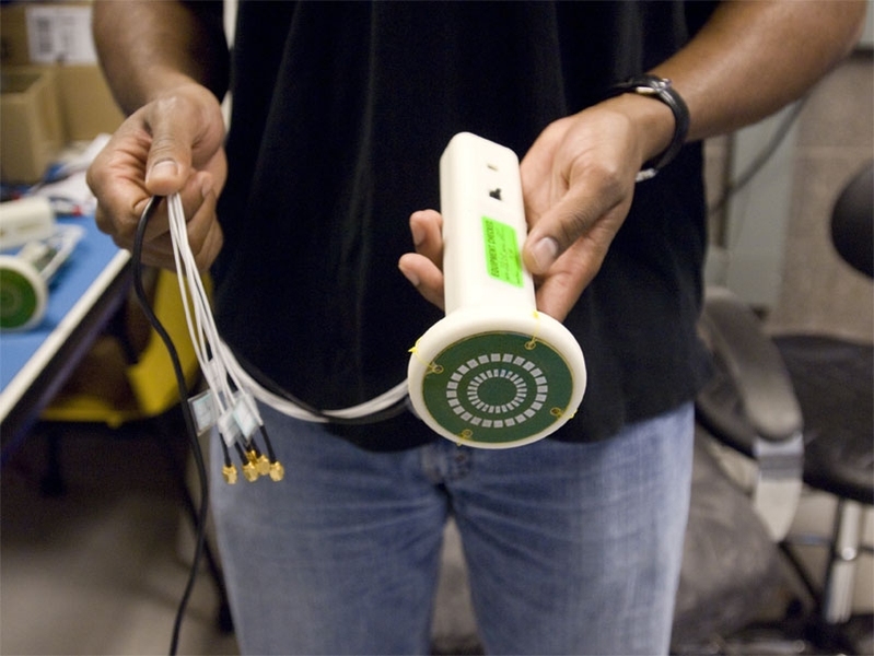 Dawson holds up a prototype of a device to measure muscle loss in patients with Lou Gehrig's Disease and other muscular ailments.
