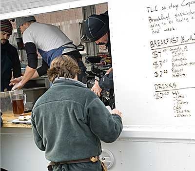 Ayr Muir ’00, SM ’01 processes an order while crews filming for the TLC show take footage inside the truck.