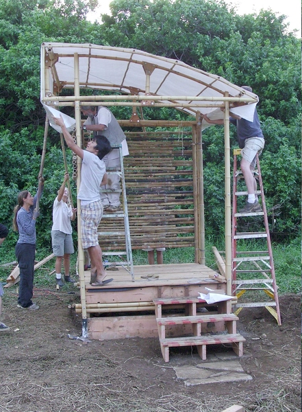 Students conduct a trial run for installing the roof fabric on their prototype structure. Due to heavy winds, it took many people to secure it in place.