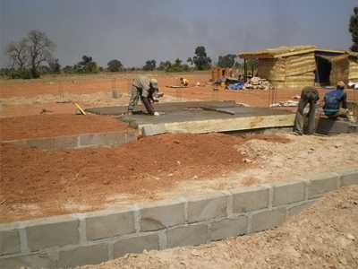 A consultant and several local villagers help the MIT team start construction of the factory this past January. Full production is expected to begin in late summer.