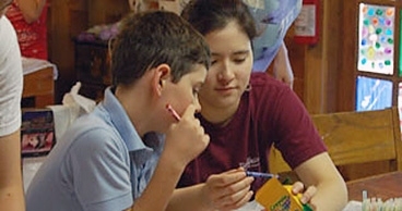 Camp Kesem camper Ryan Johnson and Caroline Huang ‘10 choose crayons for Ryan’s International Day flag. 
