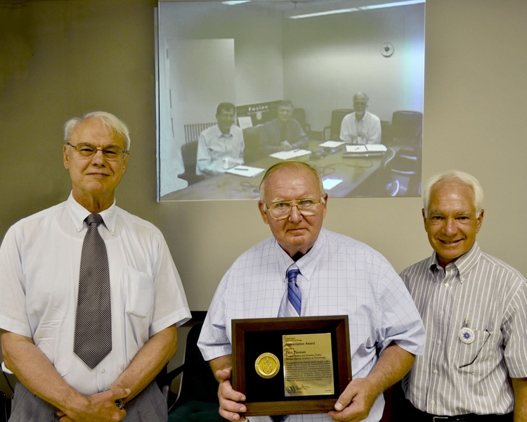 Paul Thomas (front, center), flanked by PSFC Director Miklos Porkolab (left) and MIT Vice President for Research and Associate Provost Claude Canizares (right), received an Appreciation Award via videoconference from the Department of Energy’s Associate Director for Fusion Energy Sciences, Ed Synakowski (back, right), accompanied by Acting Division Director of Research Steve Eckstrand (back, cen...