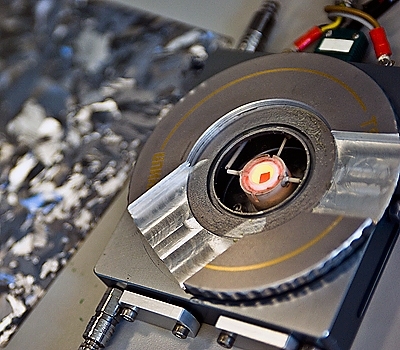 A tiny silicon chip — the glowing orange square at the center of this special heating device — is heated to a temperature well below silicon’s melting point, and then very slowly cooled down. The chip inside this heating device was placed in the path of a synchrotron beam to probe its changes at a molecular level as it went through the retrograde melting process.