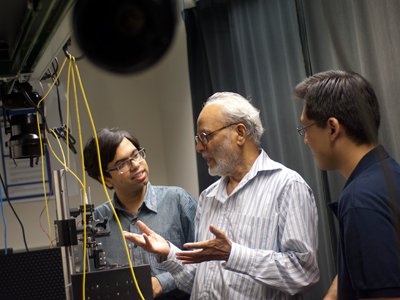 Spectroscopy Lab graduate students Ishan Barman, left, and Chae-Ryon Kong, right, talk with lab Associate Director Ramachandra Rao Dasari, center.