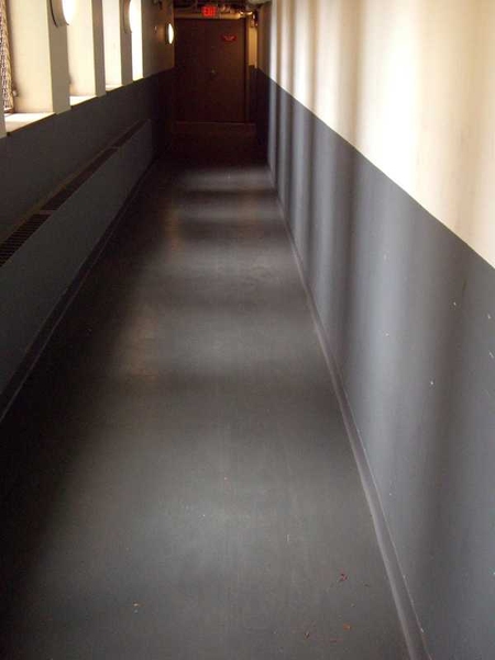 Not just a hallway — an asbestos-free hallway. Asbestos adhesive was removed and in its place is a new tile floor in Burton-Conner.  