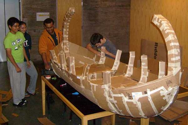 Simmons residents unite! From left, freshmen Abbel Getu, Jennifer Hsu, Victor Morales and Alex McCarthy use lots of tape to create their cardboard viking boat.
