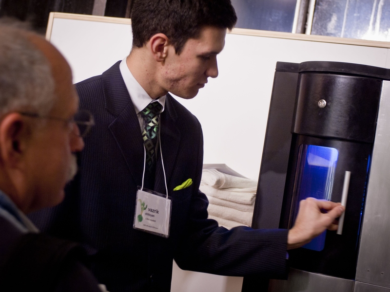 A Green team member shows off the team's product — a water-bottle sanitizer and water dispenser targeted for use in gyms.