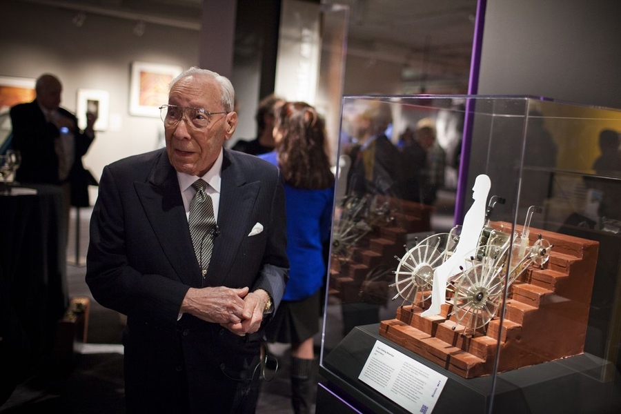 Ernesto Blanco stands near a model of his invention, the stair-climbing wheelchair, one of 150 items showcased in the museum.