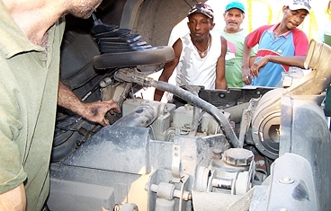 Members of the cooperative look over the modifications that have been made to one of their trucks to allow it to run on the leftover cooking oil.