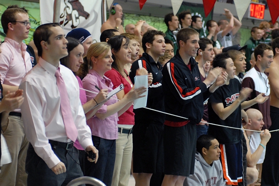 Coaches and teammates line the pool's edge to cheer on MIT swimmers during Saturday night's events.