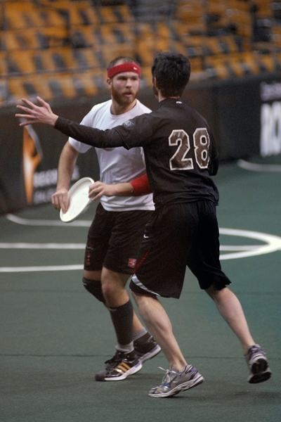 Graduate student Brian Munroe (white shirt) looks downfield for a pass. In ultimate Frisbee, the player with the disk must stay in place with one pivot foot while other players seek to get open for a pass.