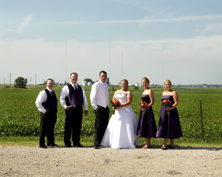 Candice and Ben Engler with their wedding party in front of a field of soybeans.
