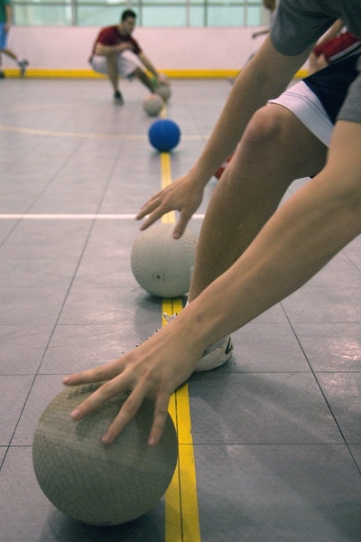Prefrosh and current students rush to grab a ball at the beginning of a dodgeball game in the Zesiger Center.