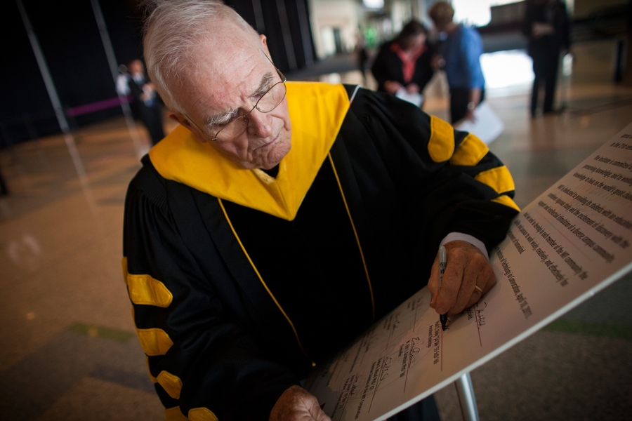 President emeritus Paul Gray signs the charter renewal.