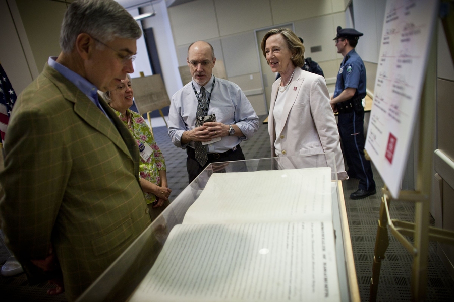 MIT President Susan Hockfield shows guest — including her husband, Dr. Thomas Byrne, left — MIT’s charter, which was signed by Massachusetts Governor John Andrew on April 10, 1861.