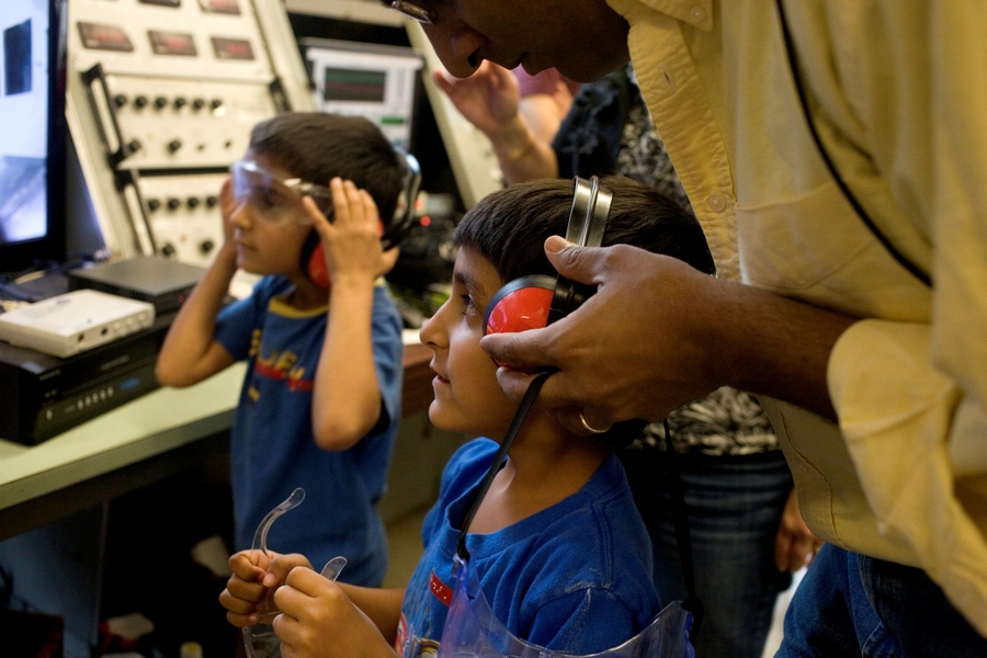 Children put on ear protectors before entering the Wright Brothers Wind Tunnel operated by the Department of Aeronautics and Astronautics.