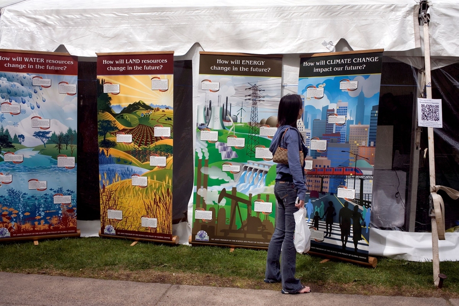 A woman looks at a poster display with information about climate change.