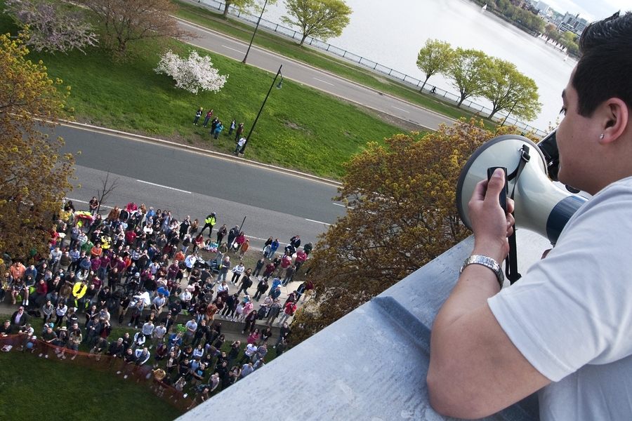 MIT senior and Baker House president Brian Luque uses a bullhorn to tell the waiting crowd six stories down that the piano is about to be dropped. 