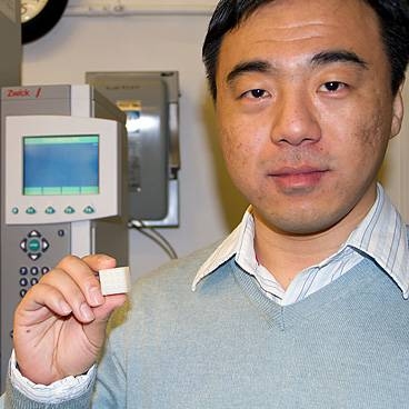 Lifeng Wang displays a cube of the new polymer composite material.