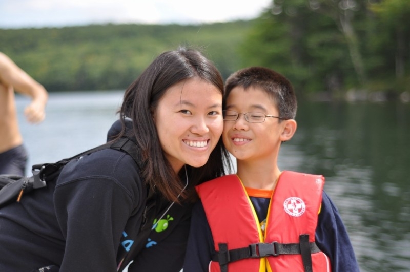 Senior Tracy Kambara poses with young Mr. Chang, happy to be swimming at Camp.