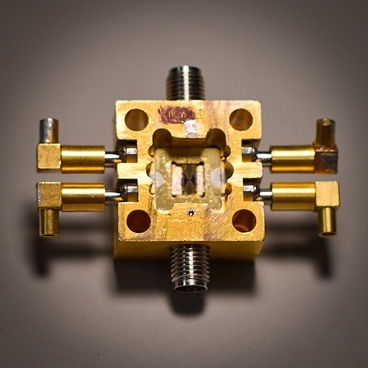 A superconducting circuit (small square, center) fits snugly into a housing that enables it to receive electrical signals inside a cooling tank.