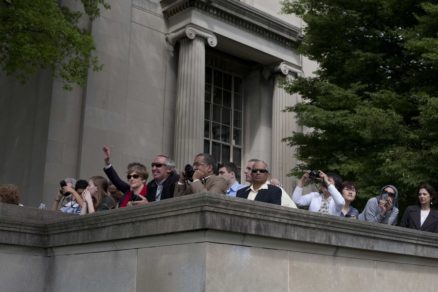 Friends and family watch their students walk toward Killian Court.
