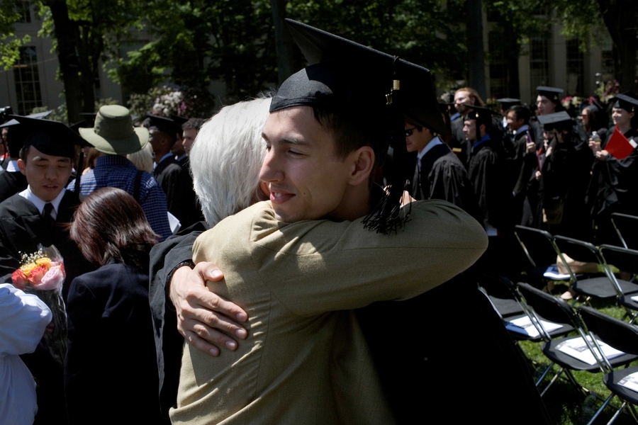 A graduate hugs a supporter after the ceremony has ended.