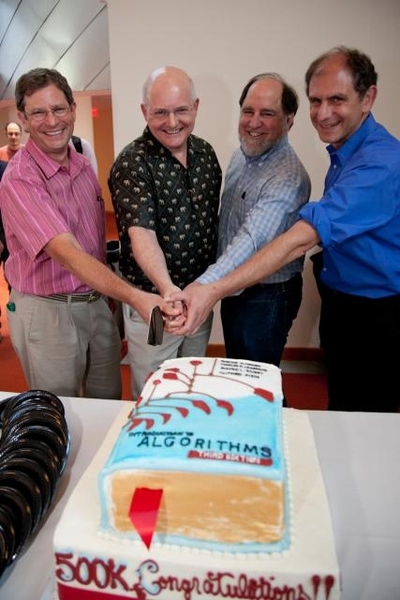 From left, the co-authors of <i>Introduction to Algorithms</i> — Thomas Cormen, Charles Leiserson, Ronald Rivest and Clifford Stein — get ready to cut a cake that replicates the cover of the book.