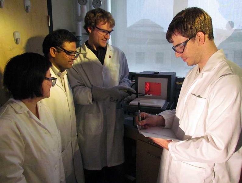 From left, mechanical engineering postdoc Yuehua Cui, professor Kripa Varanasi, and graduate students Christopher Love and J. David Smith place a sample into the oven they used to produce nanowire-covered particles.