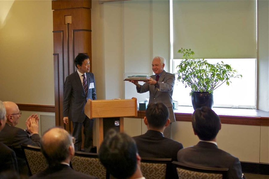 Ogata presents to Claude Canizares, MIT's vice president for research and associate provost, a model of JR East’s newest Shinkansen bullet train, the Falcon.