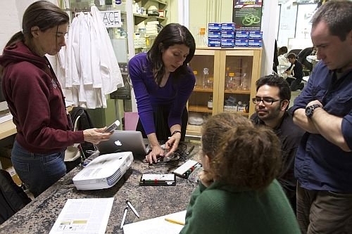 Kuldell (center left) teaches the circuitry exercise associated with bacterial photography at a community lab space — GenSpace — in Brooklyn, N.Y. The lab is the first of its kind where adults who are enthusiastic about science and engineering can work in a safe, well-equipped environment and benefit from the expertise of professional scientists who teach there. Dr. Kuldell instructed teachers...