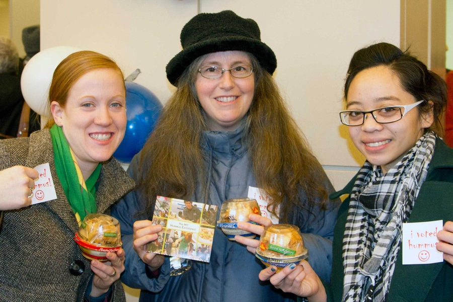 Noreen Finn (event planning assistant for Campus Activities Complex), Jennifer Smith (assistant director, Campus Activities Complex) and Edrie Ortega (graduate student in architecture) show off some of the hummus giveaways they received after voting for their favorite homemade hummus.