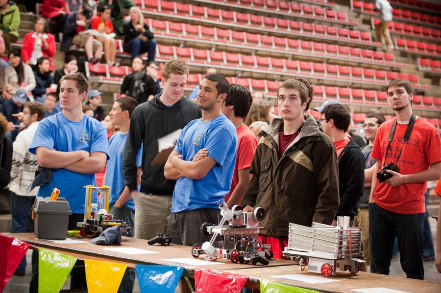 Students with their robots on the on-deck tables await their turns in the competition. Michael Farid, a sophomore from Egypt (at center in blue), placed third in the competition.