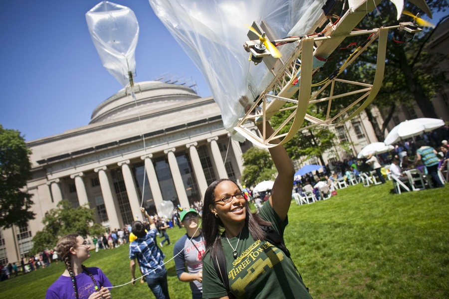 Community members fly translucent blimps, designed by students in the Department of Aeronautics and Astronautics, across Killian Court.