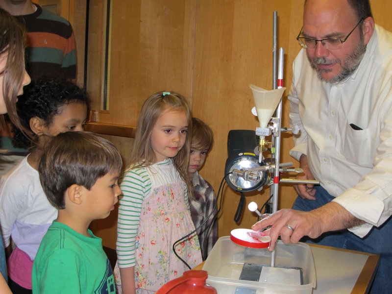 Dr. Jim Bales explains how the strobe light captures the milk splash. From left to right: Dane Robinson, Sophie Streeter, Beatrix Metral, Felix Metral and Bales.