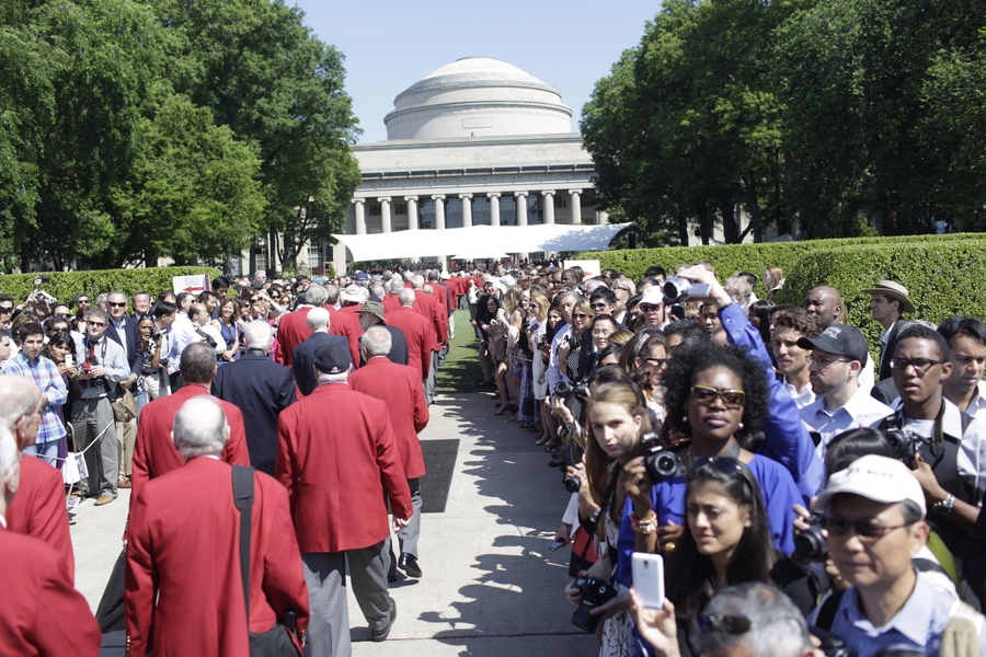 Alumni who have graduated 50 or more years ago are given red coats. Members of the Class of 1962, who received their coats this year, enter Killian Court at the beginning of the ceremony.