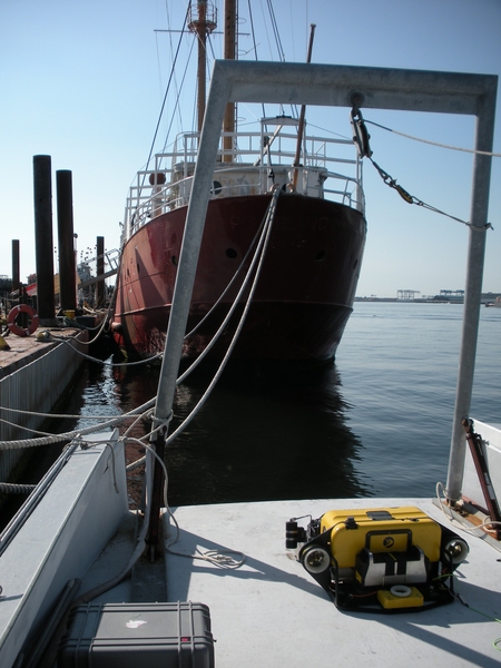 The MIT AUV (in yellow) is designed to swim around the complex structures on a ship's hull to detect small mines. The AUV navigated around the Nantucket Lightship in Boston Harbor during a test run in June 2011.