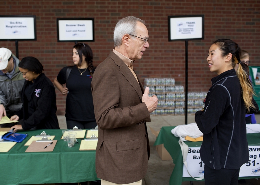 President L. Rafael Reif speaks with a runner prior to the road race.