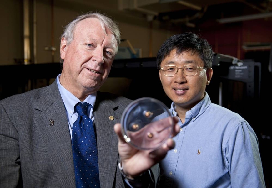 Edwin Thomas, left, and Jae-Hwang Lee display a polymer material that was tested for stopping bullets, three of which are embedded in the material.