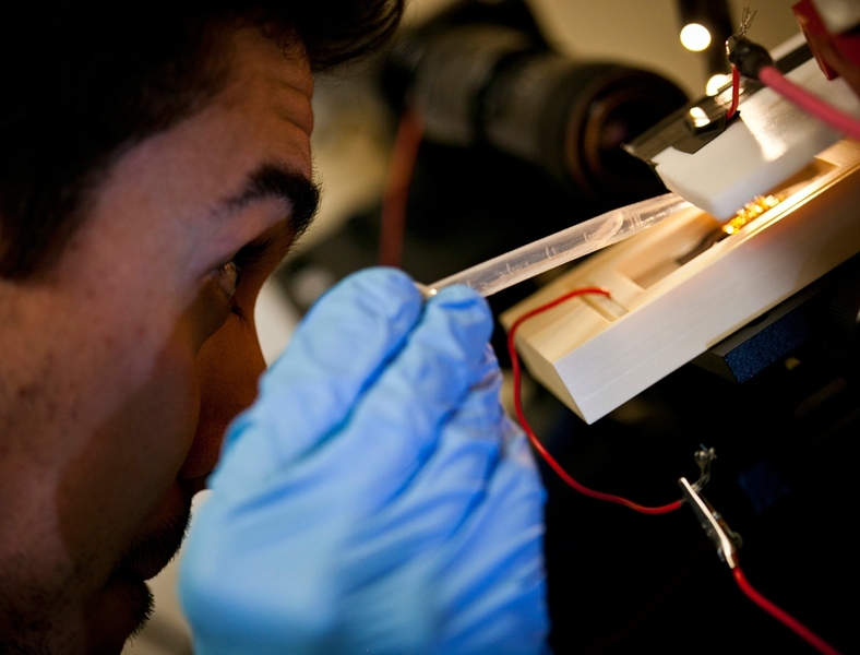 Department of Mechanical Engineering graduate student Philip Ponce de Leon adjusts the fiber-spinning apparatus.