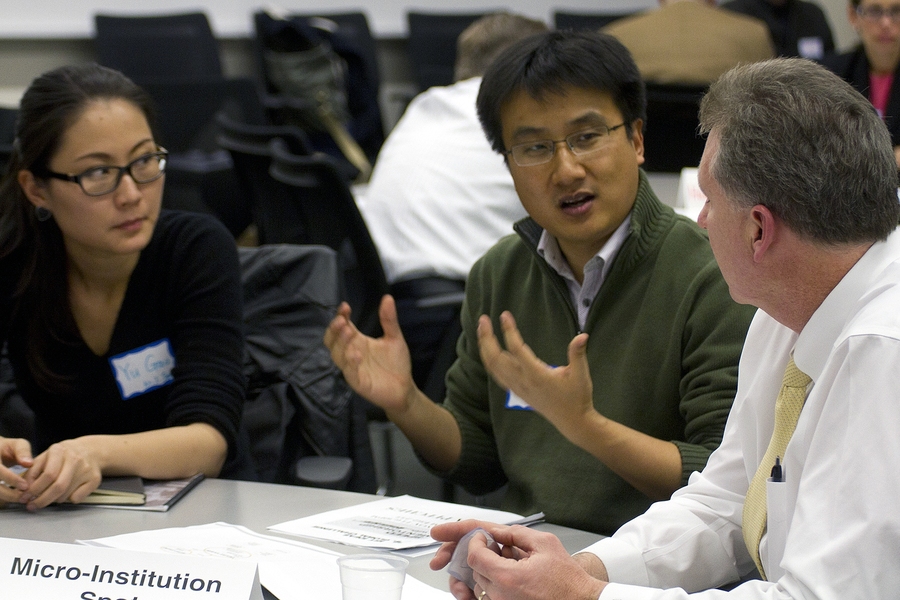 Ed Moriarty (right), general manager of the Bose ElectroForce Systems Group, listens to MIT students explain their idea on how create a community center in China to support the large migrant worker population while also investing in the artist and student community in urban areas.