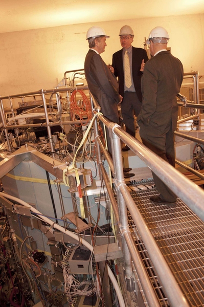 Tierney (left) discusses fusion research atop the Alcator C-Mod tokamak, with Project Head Earl Marmar and PSFC Director Miklos Porkolab.